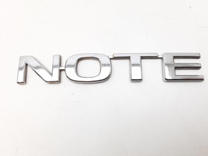 Używane Emblemat Nissan Note (E11) 1.6 16V Cena € 10,45 Procedura marży oferowane przez Japoto Parts B.V.