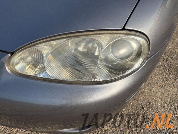 Używane Reflektor lewy Mazda MX-5 (NB18/35/8C) 1.6i 16V Cena € 157,45 Procedura marży oferowane przez Japoto Parts B.V.