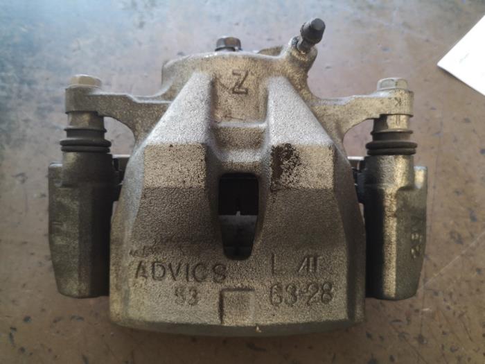 Front brake calliper, left from a Toyota Auris Touring Sports (E18) 1.8 16V Hybrid 2015