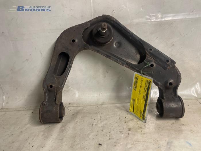 Front upper wishbone, left from a Nissan Navara (D40) 2.5 dCi 16V 4x4 2006
