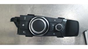Używane Przycisk I-Drive Mazda 2 (DJ/DL) 1.5 e-SkyActiv G 90 Cena € 75,00 Procedura marży oferowane przez De Witte Boerderij B.V.